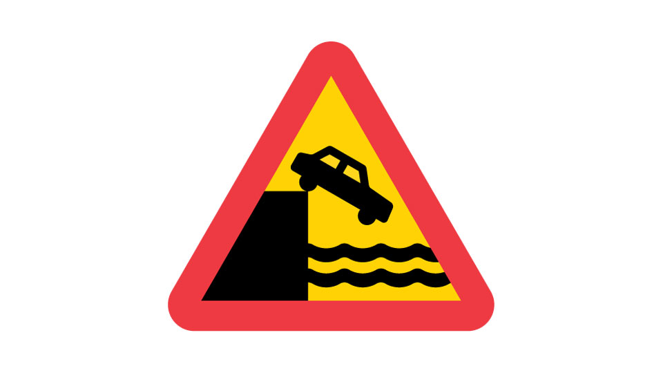 Red-and-yellow triangle with a car at a quay edge above waves.